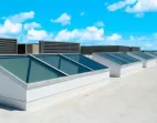 Butted glass skylights on a reflective roof